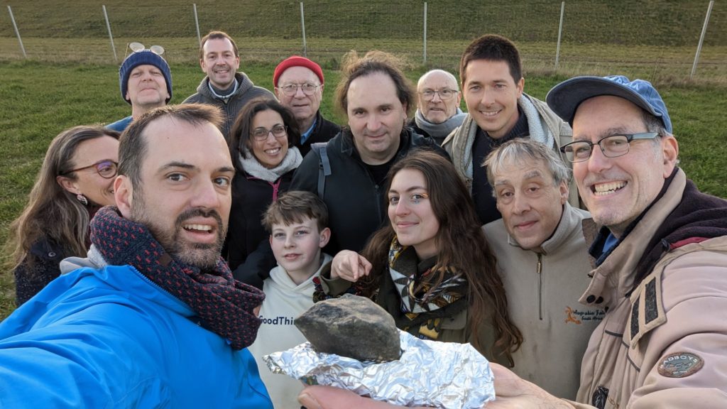Figure 1- First meteorite coming from 2023 CX1 surrounding by the whole research team organised by the citizen science program Vigie-Ciel. Credit: FRIPON/Vigie-Ciel